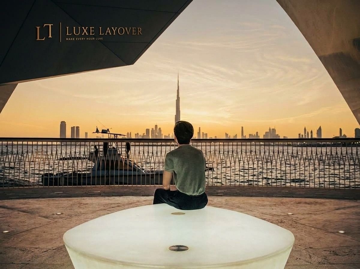 A person sitting on a round white bench overlooking the Dubai skyline and Burj Khalifa at sunset