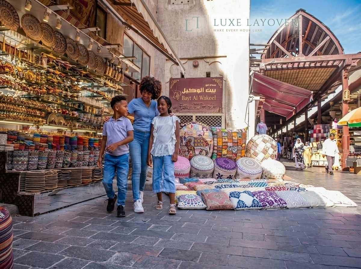 A family walking hand in hand through a covered traditional souk market lane