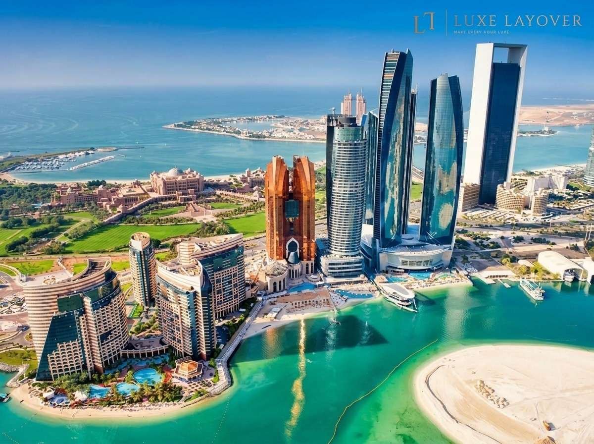 Aerial view of Abu Dhabi's waterfront skyline including the twin Etihad Towers area with a sandy