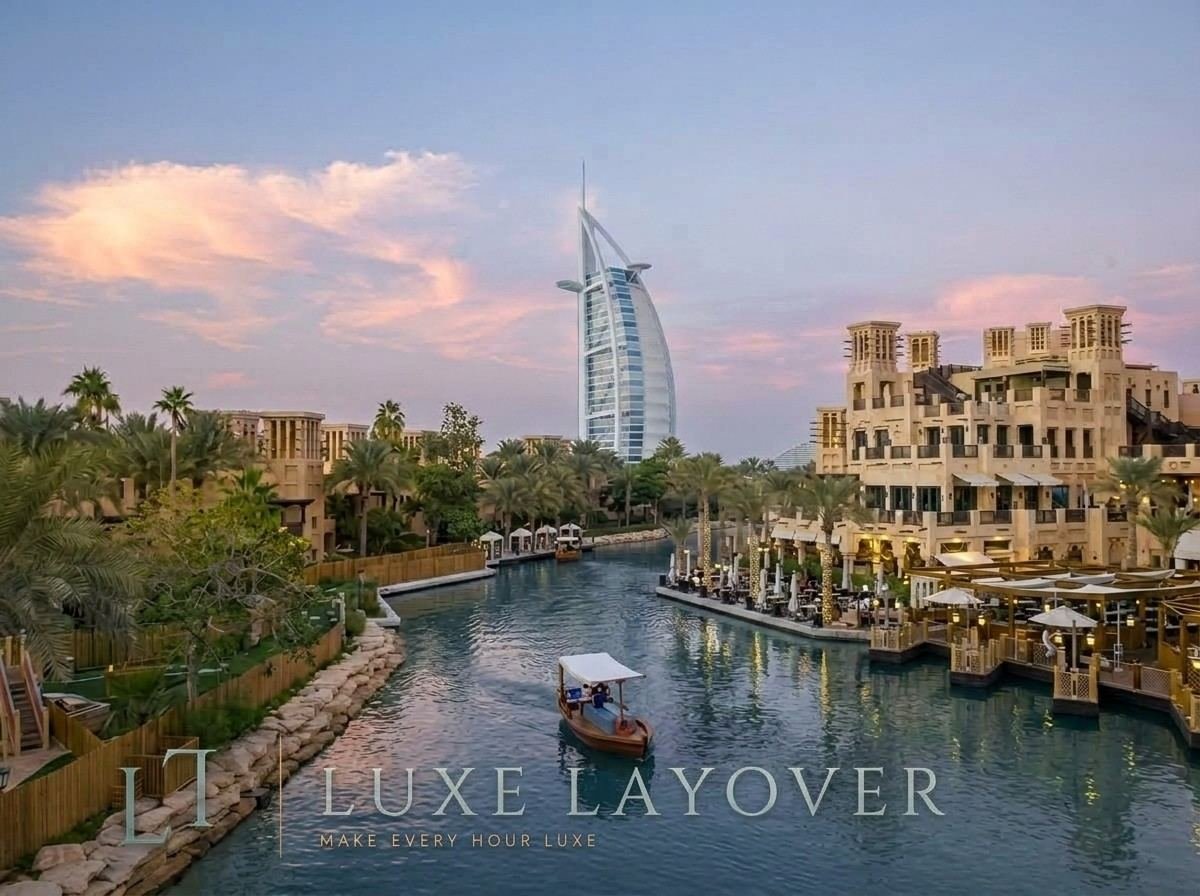 A traditional abra boat gliding along a waterway at Madinat Jumeirah with Burj Al Arab in the