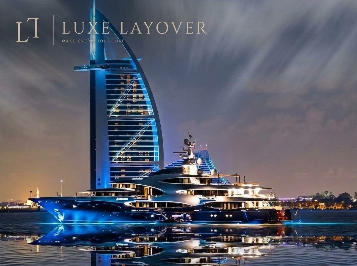 Burj Al Arab illuminated at night with a luxury yacht anchored nearby