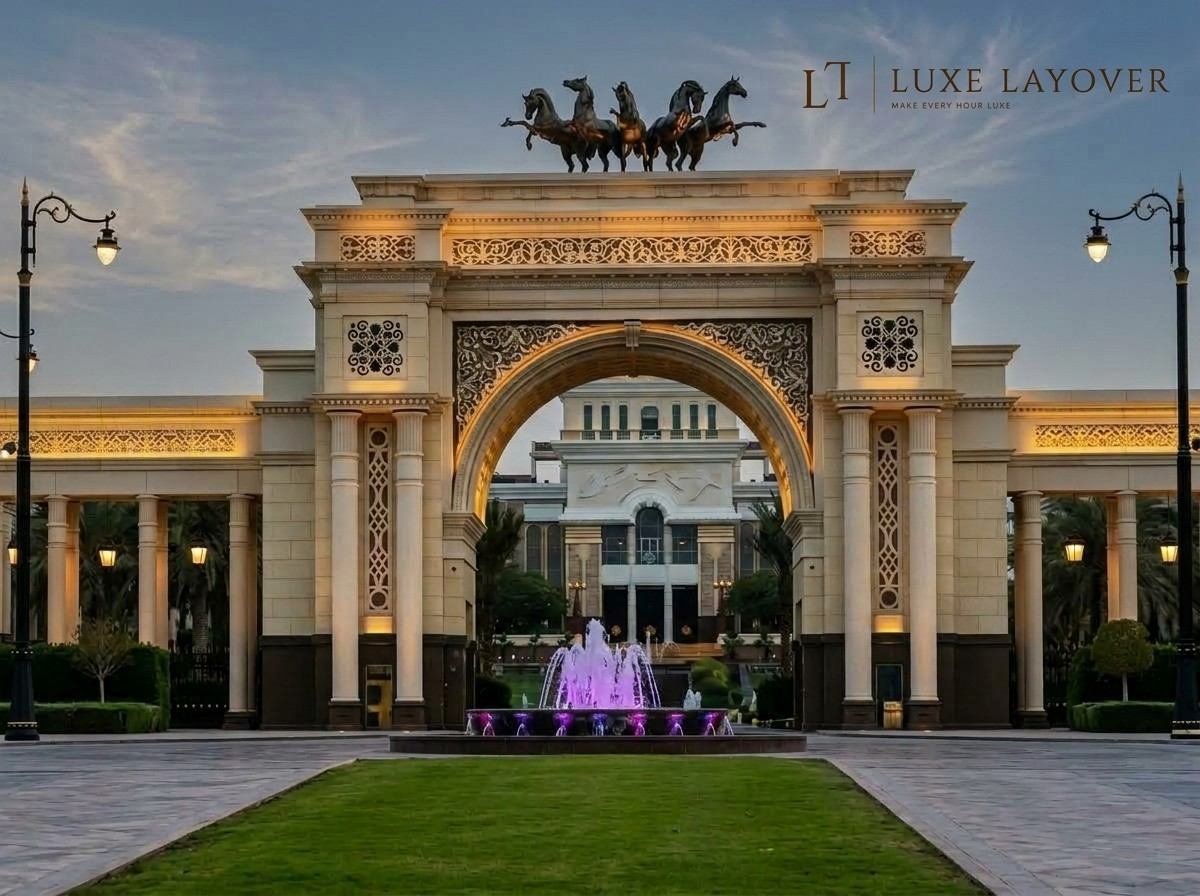 A grand ceremonial archway entrance flanked by ornamental horse statues, with fountains in the