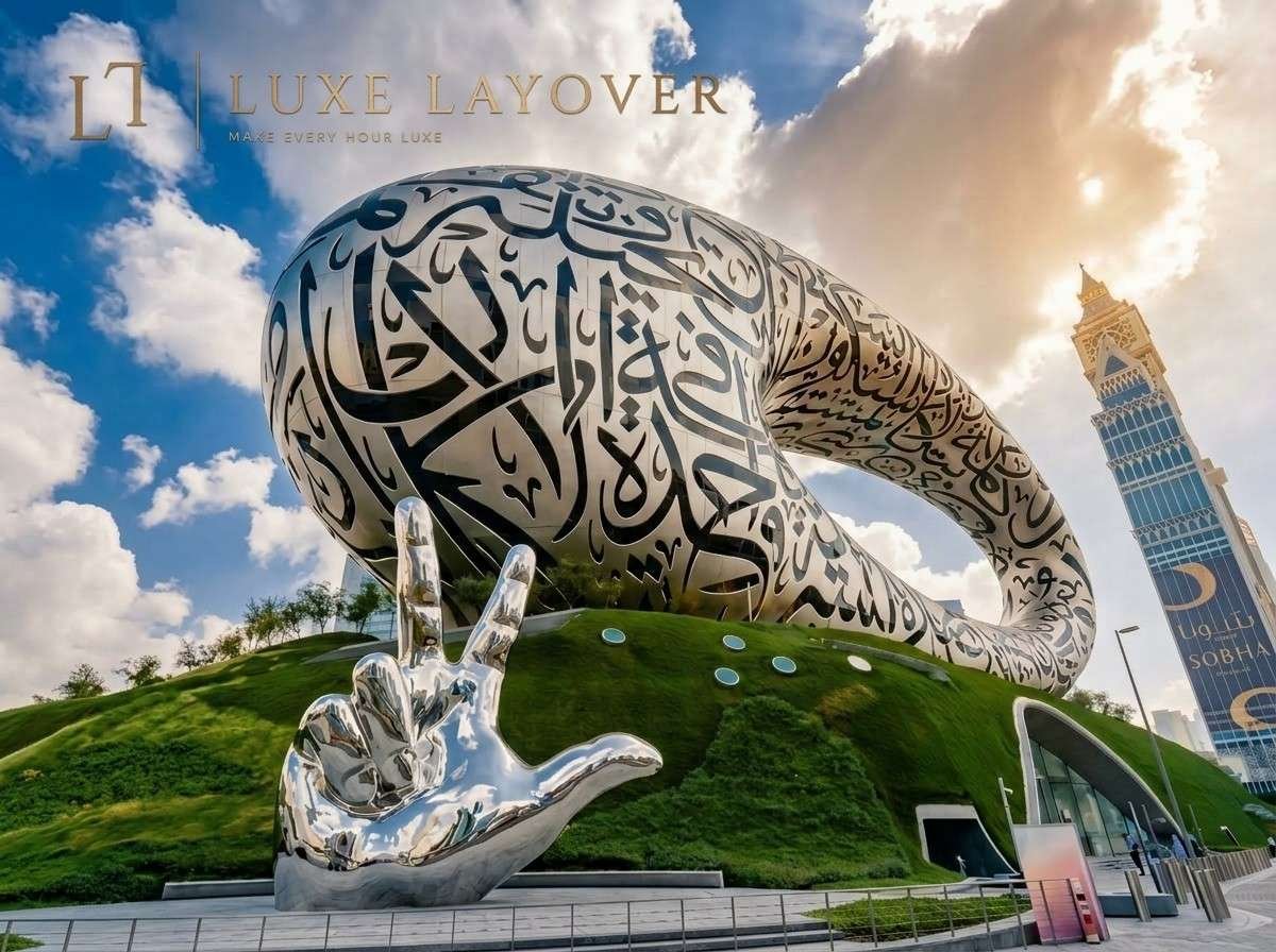 A wider view of the cupped-hands stainless-steel sculpture with Arabic calligraphy on a grassy