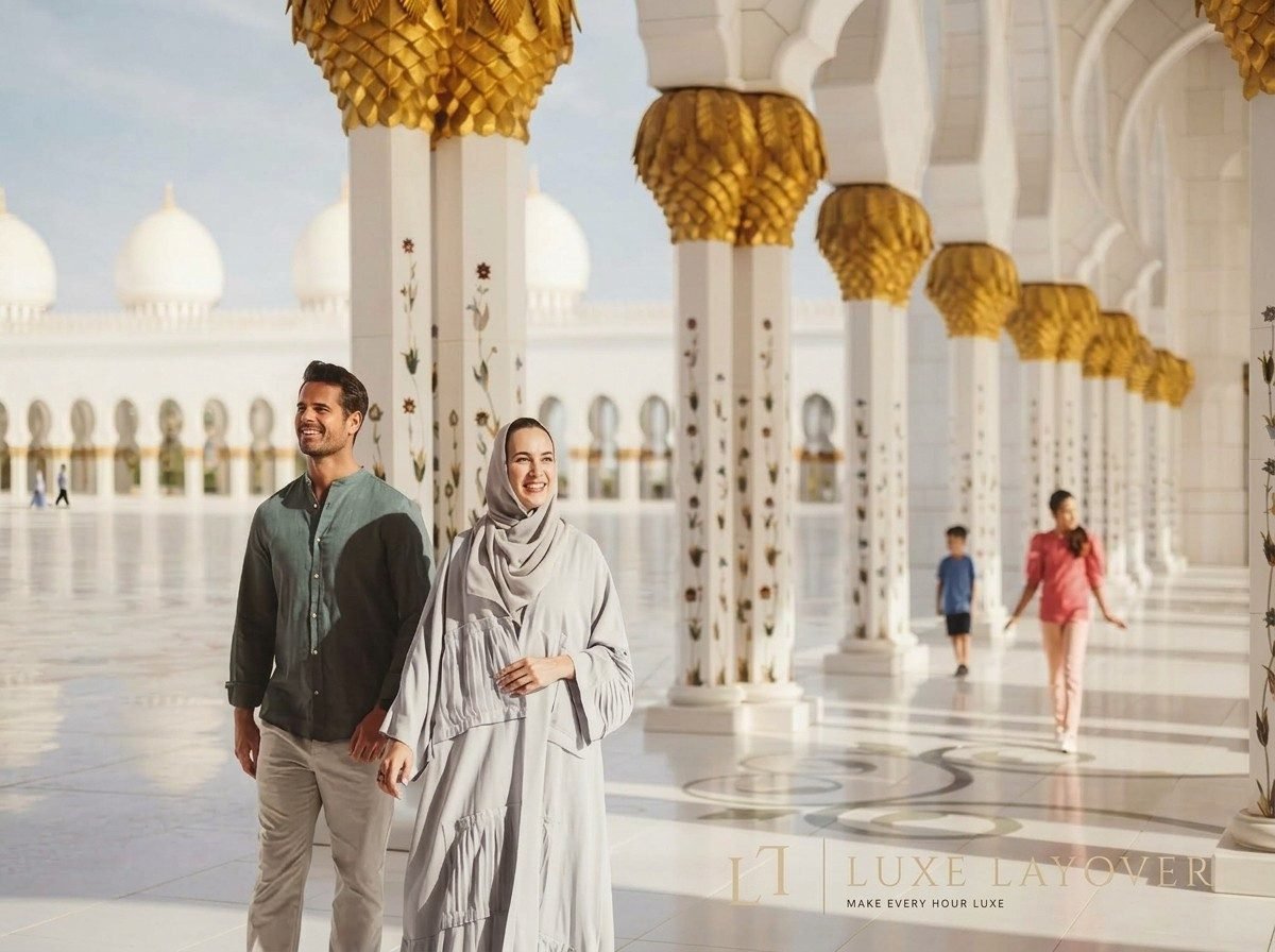 A couple standing among the mosque's marble columns in the courtyard of Sheikh Zayed Grand Mosque