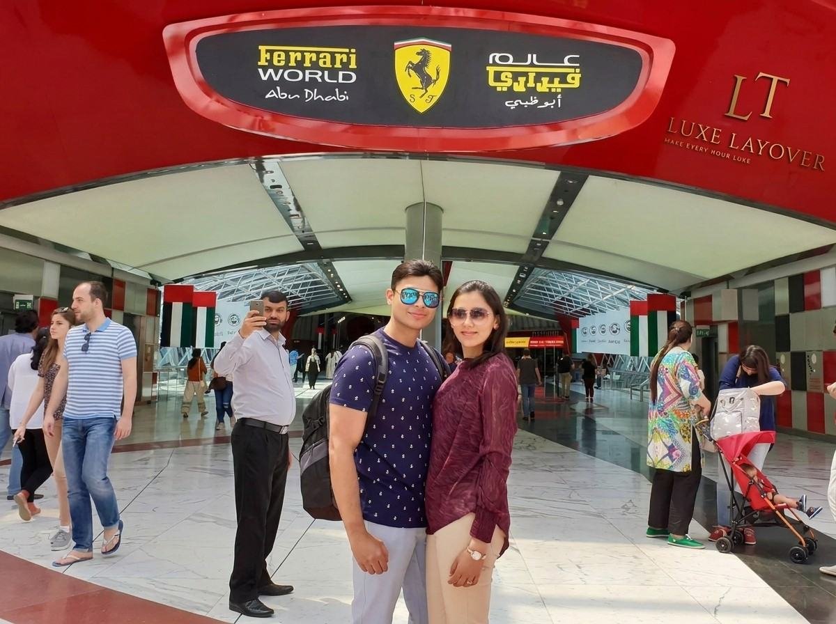 A family posing at the entrance of Ferrari World theme park