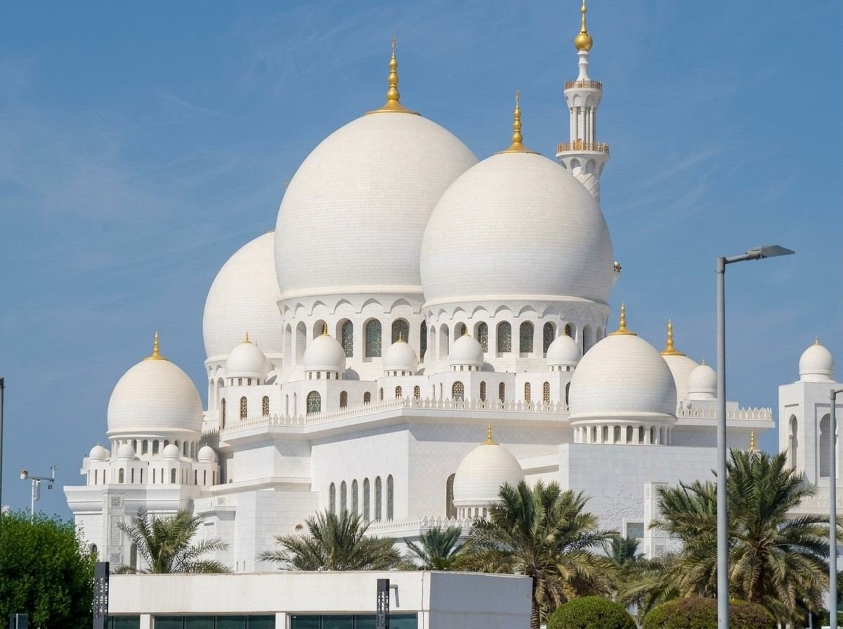 Sheikh Zayed Grand Mosque exterior framed by palm trees