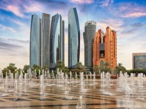 The Etihad Towers skyscrapers with illuminated fountains in the foreground at dusk