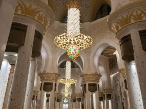 A close-up of an ornate gold and crystal chandelier inside a mosque