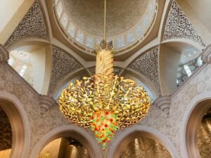 A large ornate gold chandelier hanging inside a grand hall