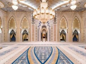 An arched hall interior decorated in blue and gold mosaic patterns