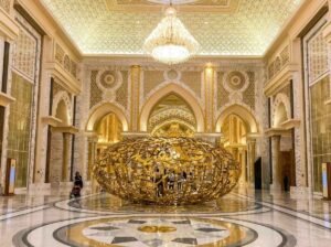 A large ornate gold decorative sculpture centred in a marble palace lobby
