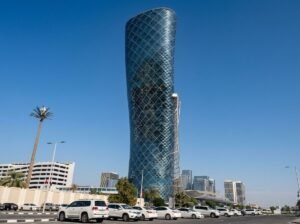 A distinctive cylindrical modern office tower rising above a city street