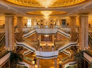 A multi-storey palace lobby atrium with ornate columns and a domed ceiling
