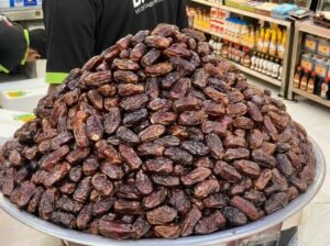 A large pile of dates displayed for sale at a market stall